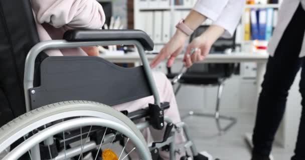 Доктор вставляє коліно пацієнта в інвалідне крісло з молотком. Оніміння нижніх кінцівок ніг та концепції травм хребта
 - Кадри, відео