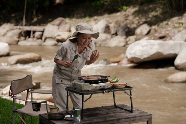 Азійка подорожує і веде кемпінг і готує смажені страви. Подорожуйте вуличним життям - Фото, зображення