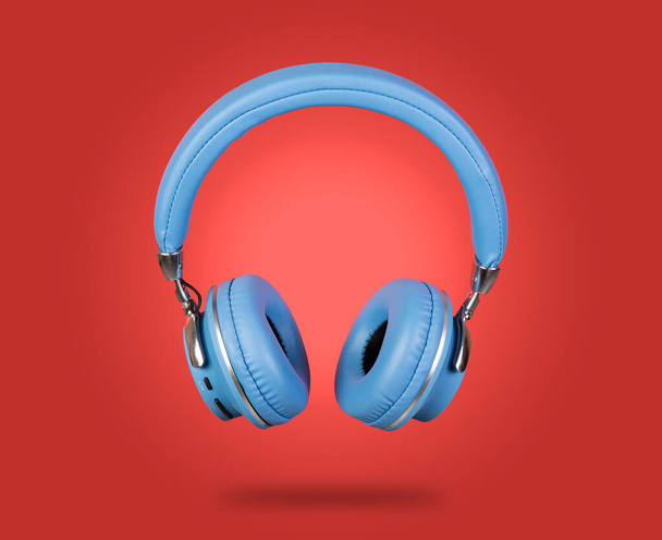 Blue color Isolated wireless headphone with red banner template. - Фото, изображение