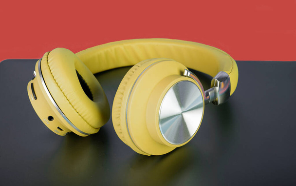 Yellow color wireless headphone closeup concept of music and exercise. - Фото, изображение