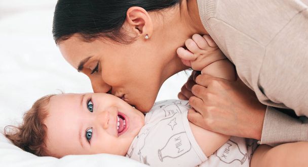 Mom gives the sweetest kisses. a woman bonding with her adorable baby boy at home - Foto, Bild