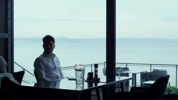 Attractive entrepreneur waiting partner for business lunch in lounge hotel bar. Successful man enjoying weekend dinner in premium restaurant. Relaxed employee silhouette spending break in luxury cafe. - Πλάνα, βίντεο