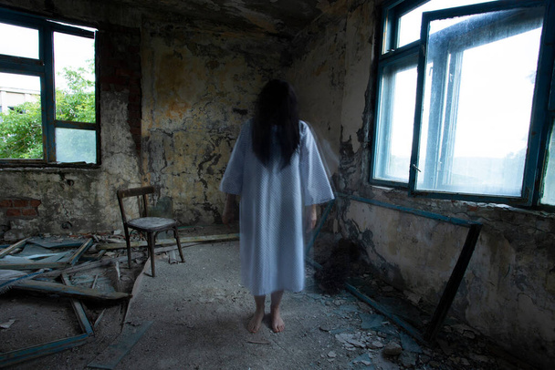 Ghost in abandoned, haunted house. Horror scene of scary spirit of a woman, halloween concept. - Fotoğraf, Görsel