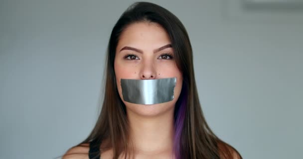 Woman mouth taped looking at camera - Séquence, vidéo