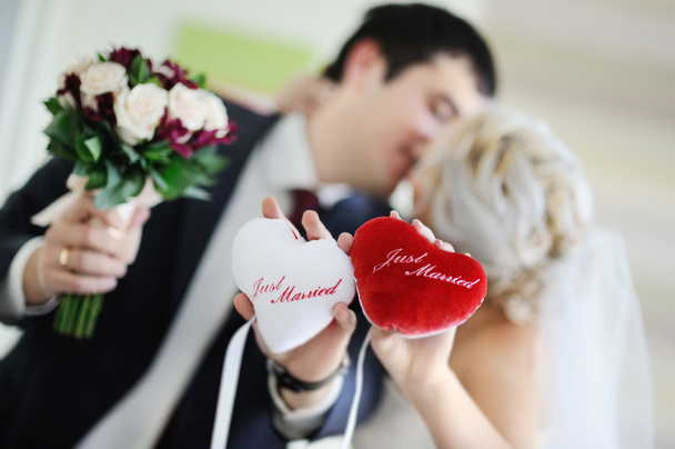 Newlyweds are holding the pads in the shape of a heart with the  - Photo, Image
