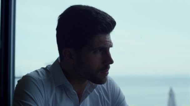 Attractive man relaxing panoramic hotel bar portrait. Thoughtful guy looking beautiful seascape waiting for business meeting in restaurant profile. Pensive male face expression closeup. - Filmati, video