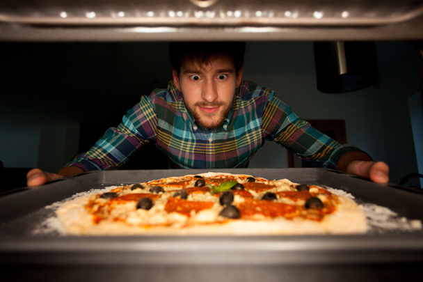 Man taking pizza from oven - Foto, imagen