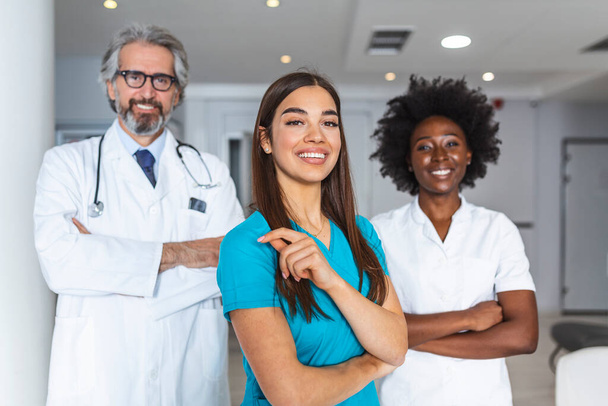 Mediziner stehen zusammen. Konzept des Gesundheitsschutzes. Erfolgreiches Ärzteteam blickt in die Kamera und lächelt im Krankenhaus - Foto, Bild