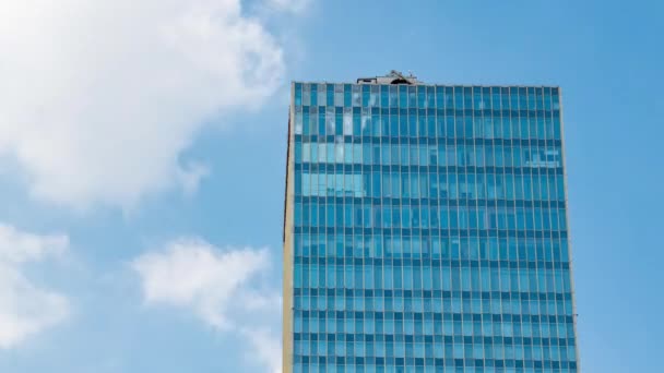 Partial blue sky and white clouds of high-rise buildings with glass curtain walls in sunny summer - Filmati, video