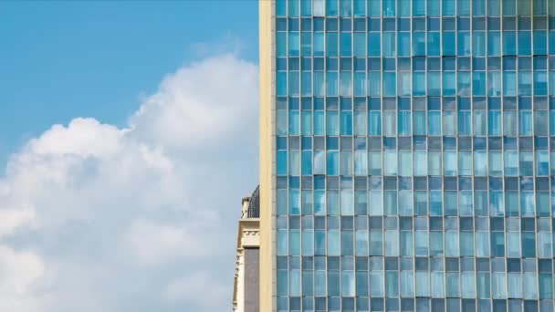 Kısmi mavi gökyüzü ve güneşli yaz aylarında cam perdeleri olan yüksek binalardan oluşan beyaz bulutlar. - Video, Çekim