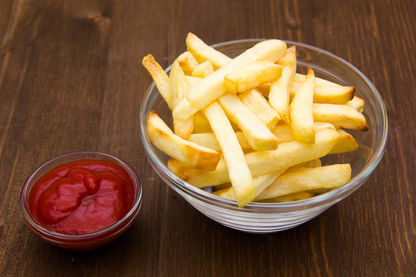 Bowl of chips and ketchup on wood - Photo, Image