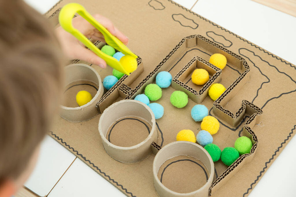 Pompom train. 3D train board for active brain exercise game made from paper core tubes and cardboard. Montessori methodology task to sort different colors. - 写真・画像
