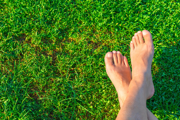 Les pieds des hommes sur le fond d'herbe verte luxuriante
 - Photo, image