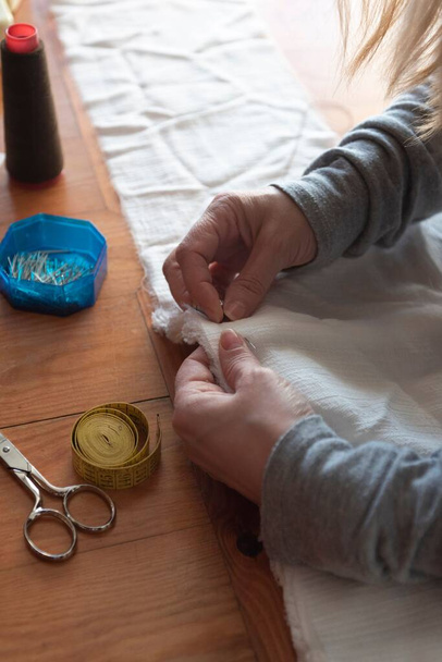 A female carefully sewing white cloth - Foto, Imagem