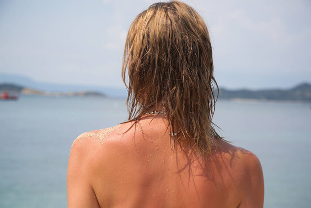 Kobiece włosy na plaży. Mokre włosy z bliska. Uszkodzenie włosów ze względu na słoną wodę oceaniczną i słońce, letnia koncepcja pielęgnacji włosów. - Zdjęcie, obraz