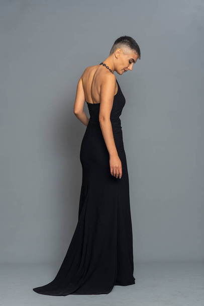 Beautiful tall girl with a haircut like a man in a long closed dress - Foto, afbeelding