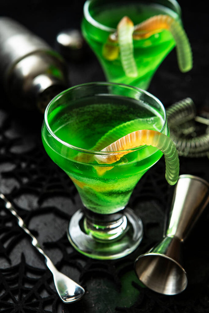 Halloween composition with festive drink, green cocktail and bar accesories on night dark background, selective focus - Fotografie, Obrázek