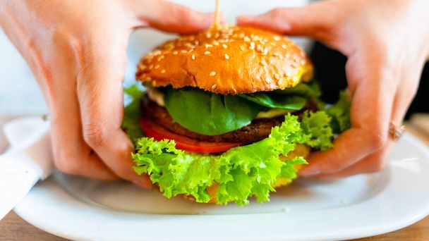 Веганський бургер здоровий вегетаріанський гамбургер. Салат, авокадо, овоч на вегетаріанському сендвічі їдять милу жінку. Вегетаріанський гамбургер здорове дієтичне харчування
 - Фото, зображення