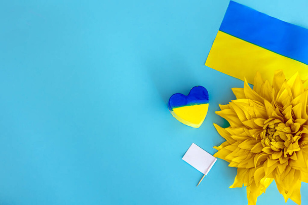 Flat lay composition with yellow sunflower flower and Ukrainian flag, copy space. - Foto, Imagem