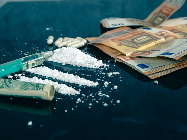 Pénz és drog egy fekete üvegasztalon. Pénz, fecskendő és kábítószer. - Fotó, kép