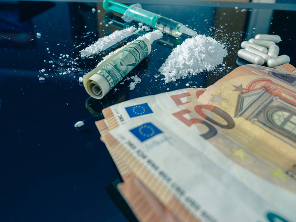 Money and drugs on a black glass table. Money, syringe and drugs. - Photo, Image