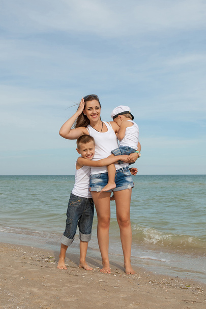 Mother and her two sons having fun on the beach - Photo, Image