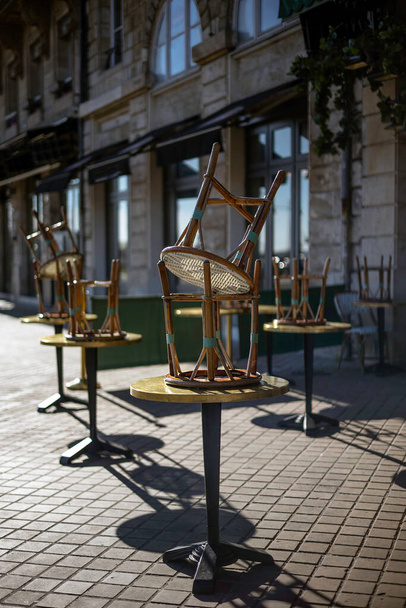 An empty outdoor area of a traditional french restaurant or cafe in a historic downtown. Tables and chairs without visitors.  Business in HoReCa. - Foto, imagen