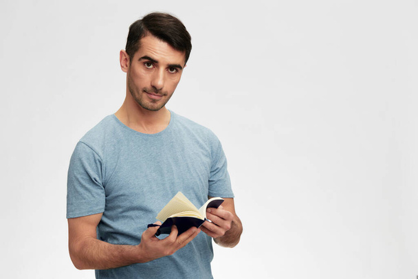 man writes in a notebook t-shirt glasses lifestyle light background. High quality photo - Photo, Image