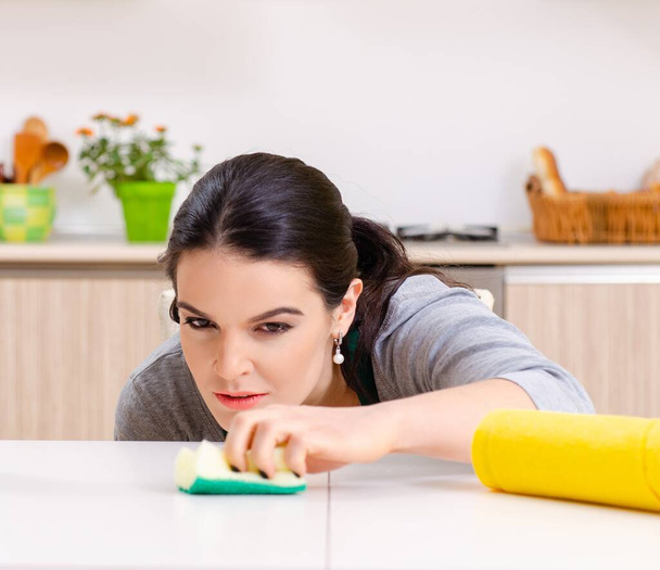 A jovem empreiteira fazendo trabalhos domésticos
 - Foto, Imagem
