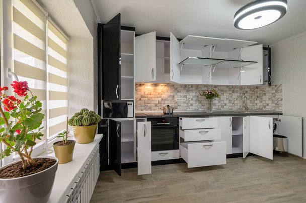 Interior renovation showcase of well designed modern trendy white kitchen, cabinet doors open, drawers retracted - Fotoğraf, Görsel