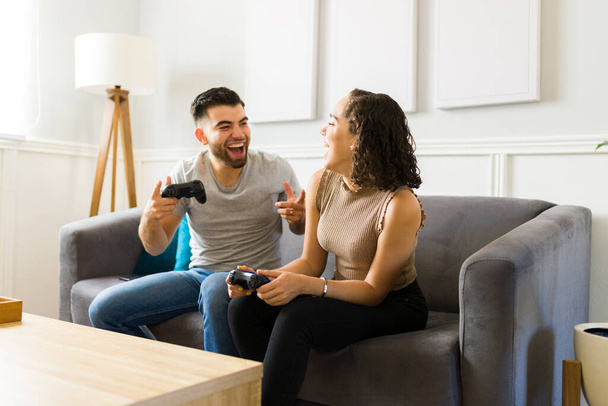 Fröhlich attraktiver Mann feiert den Gewinn eines Videospielspiels mit seiner glücklichen Freundin, die Spaß hat  - Foto, Bild