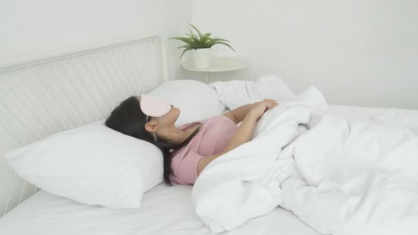 Schöne junge asiatische Frau trägt Deckauge und schläft auf dem Bett mit dem Kopf auf dem Kopfkissen Komfort und Glück im Schlafzimmer zu Hause, Mädchen mit Entspannung und Muße für Wellness, Lifestylekonzept. - Filmmaterial, Video