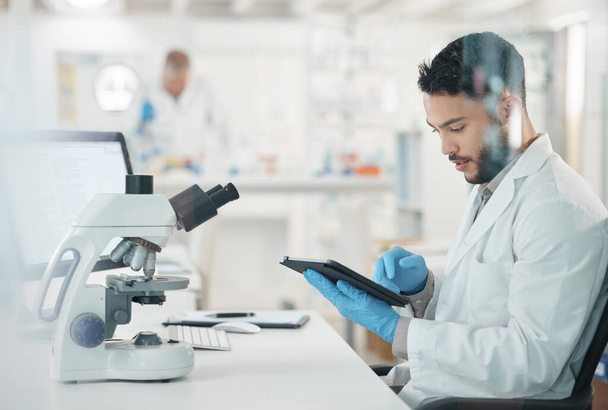 Making informed decisions based off his thorough research. a young scientist using a digital tablet while working in a lab - Foto, Imagem