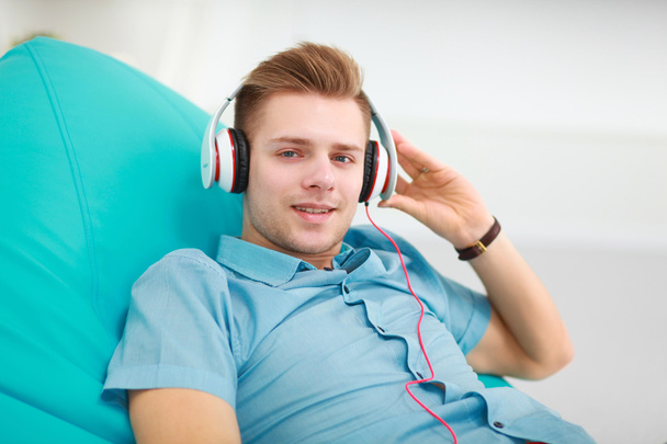 Man listening music in headphone on the sofa at home - Foto, immagini