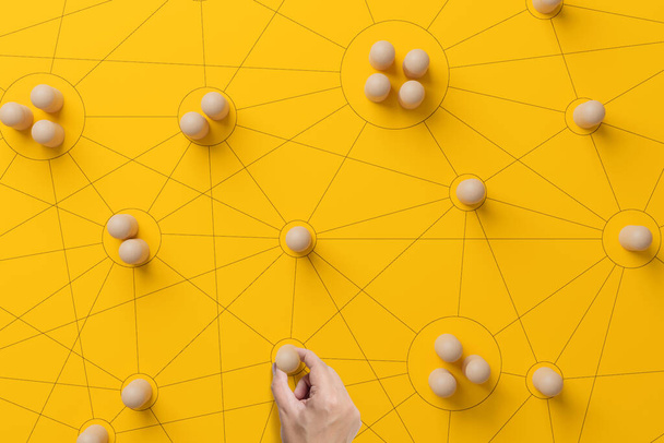 Human resource management and recruitment business. Social network connection. Group society communication. Hand holding wood cube people on yellow background - Foto, immagini