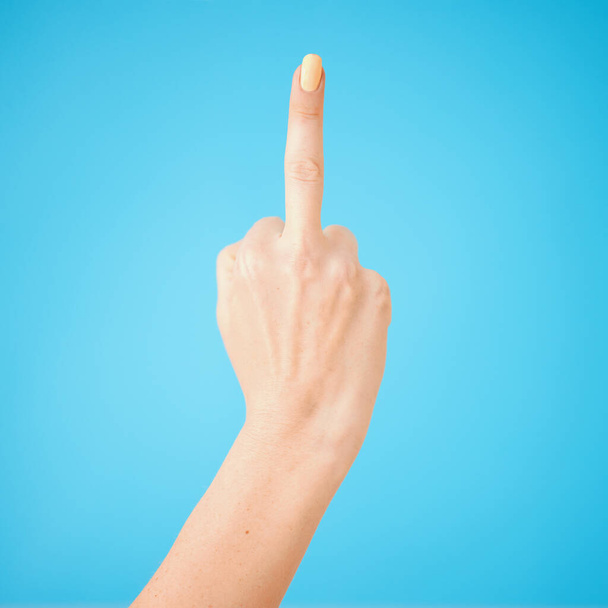 If you make me mad, youll get one of these. Studio shot of an unrecognisable woman showing her middle finger against a blue background - Foto, Bild