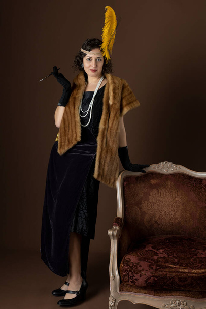 A 1920s woman wearing a party dress and a headband with a feather - Foto, Imagem