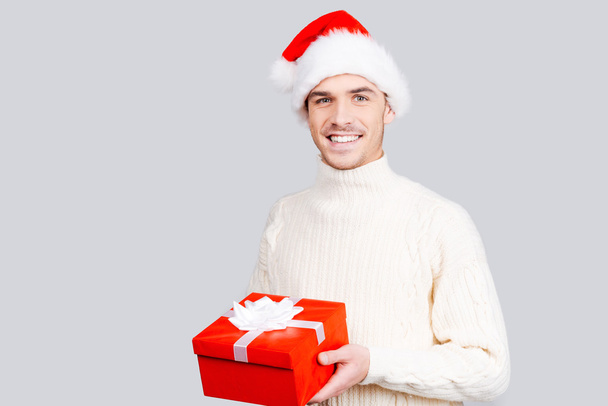 Man in Santa hat holding a gift box - Fotó, kép