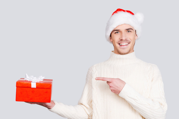 Man in Santa hat holding a gift box - Fotó, kép