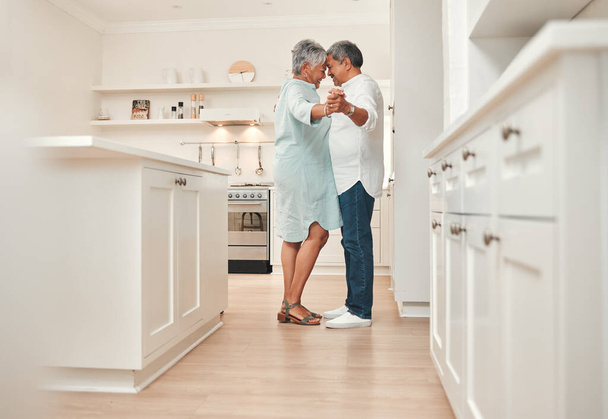 I said until were old and grey... a mature couple dancing in the kitchen at home - Фото, изображение