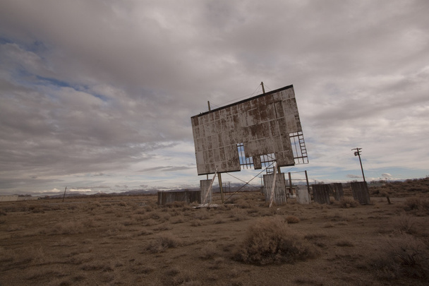 Velho cinema drive-in abandonado em um deserto dia nublado
 - Foto, Imagem
