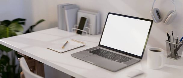 Moderna scrivania da ufficio bianca con portatile portatile notebook schermo bianco mockup e accessori per ufficio. immagine ravvicinata. rendering 3d, illustrazione 3d - Foto, immagini