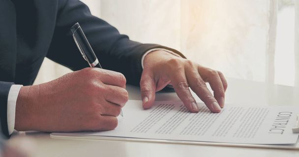 Επιχειρηματίας χέρι χρησιμοποιώντας στυλό υπογραφή για τη νέα σύμβαση για την έναρξη έργων στην αίθουσα συνεδριάσεων. Κοντινό πλάνο διευθυντής επιχειρήσεων χέρια άνθρωπος υπογράψει συμβόλαιο νομικό έγγραφο στην αίθουσα συνεδριάσεων. Έννοια επιχειρηματικής συμφωνίας - Φωτογραφία, εικόνα