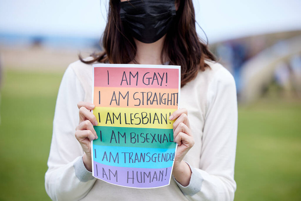 It doesnt make me less of a human. a woman holding up a sign at an lgbtq rally - Foto, imagen