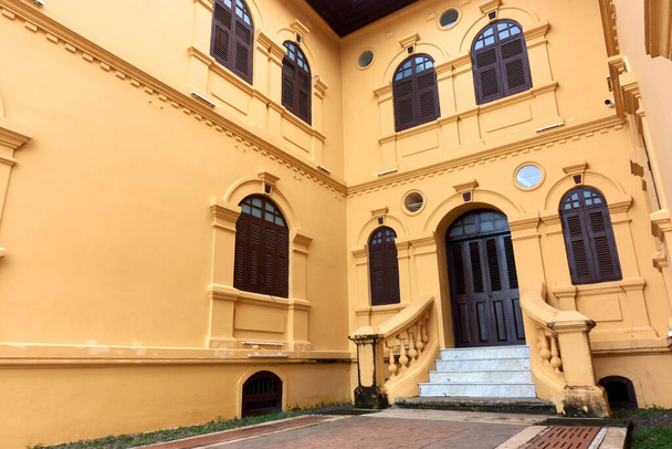 Starożytny żółty budynek architektury kolonialnej Istnieją piękne elementy dekoracyjne stiukowe, drzwi i okna. - Zdjęcie, obraz
