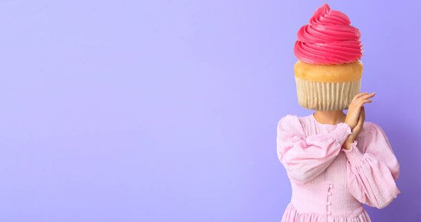 Kobieta ze słodką babeczką zamiast głowy na liliowym tle z miejscem na tekst - Zdjęcie, obraz