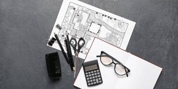 Landscape designer's plan with stationery, notebook and eyeglasses on dark background - Photo, Image