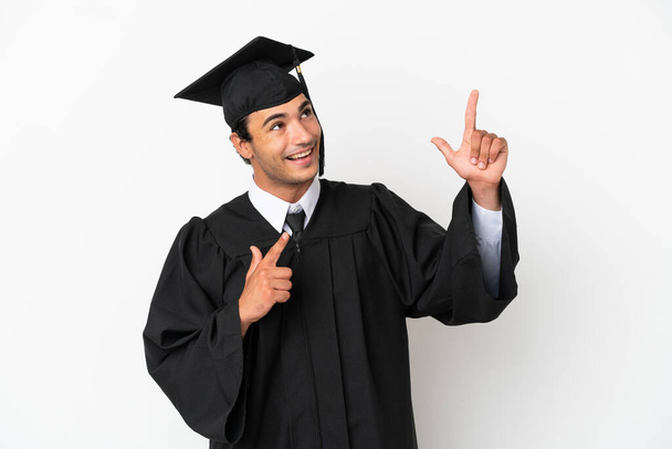 Молодий випускник університету над ізольованим білим тлом, вказуючи на індексний палець чудова ідея
 - Фото, зображення