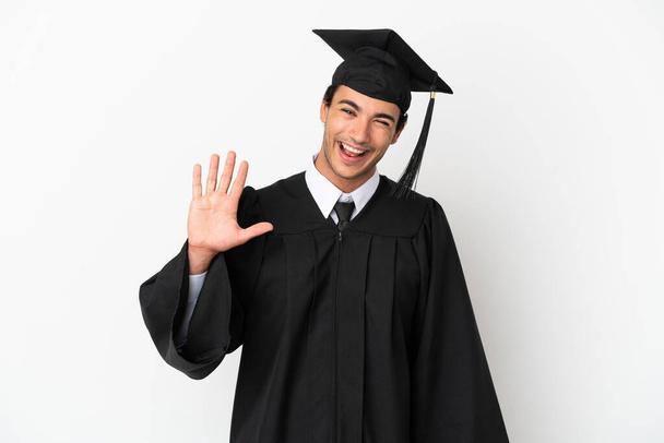 Young university graduate over isolated white background saluting with hand with happy expression - Photo, Image