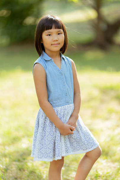 Cute little Korean girl standing in the park on a sunny day - Photo, Image